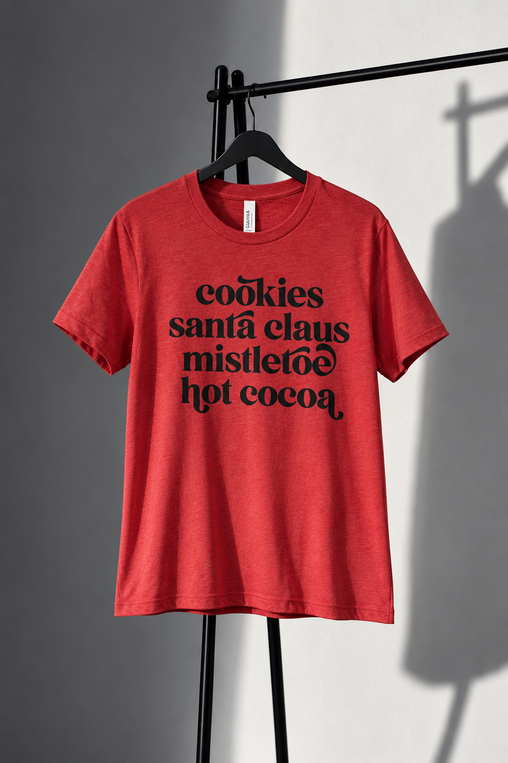 Red Bella Canvas tee with black cookies Santa Claus mistletoe and hot cocoa lettering