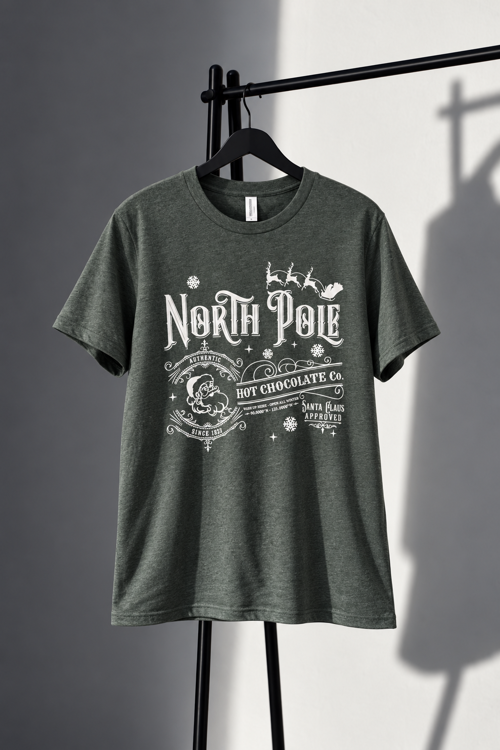 Heather green Bella Canvas tee with white vintage North Pole Hot Chocolate Co Christmas screen print