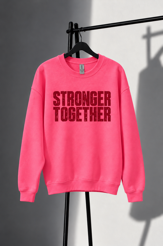 Neon pink Stronger Together sweatshirt with straight horizontal lettering on black studio rack